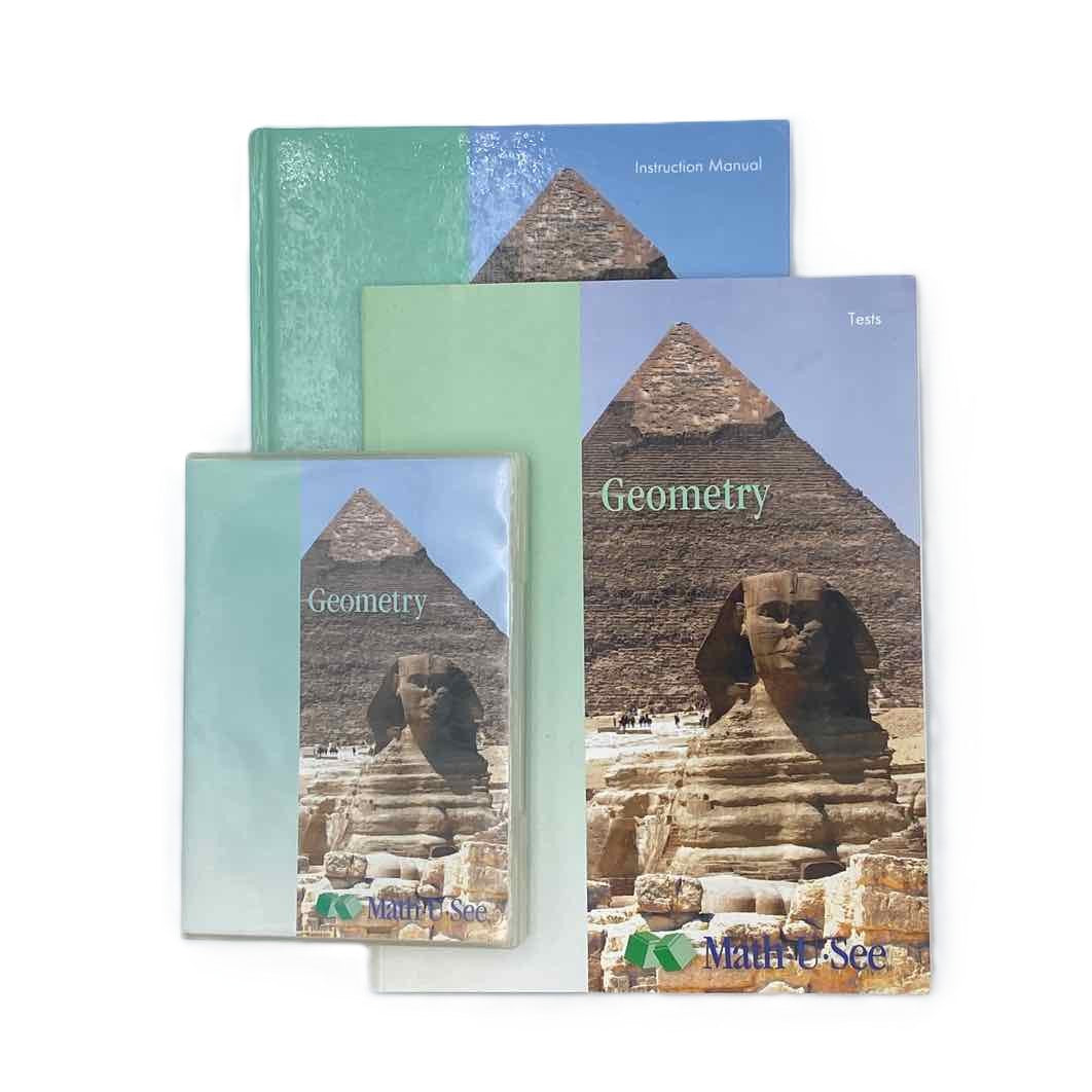 Math-U-See Geometry Instruction Manual (printed upside down), DVDs & Test Booklet on a white background.